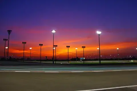 An empty racing circuit under floodlights at sunset