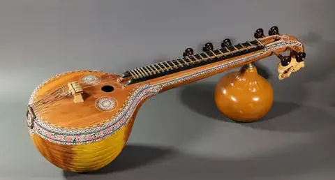 A Saraswati veena lying on a grey background