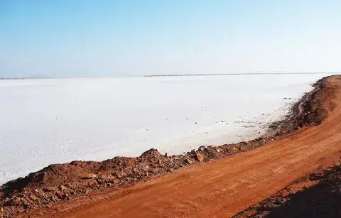 The white salt desert of the Rann of Kutch beside a red earth track