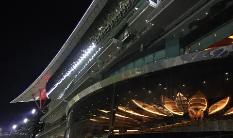 The Meydan Racecourse grandstand in Dubai, lit up at night