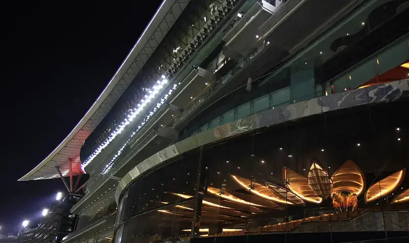 The Meydan Racecourse grandstand in Dubai, lit up at night