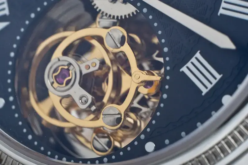 Close-up of a watch tourbillon behind a dark blue dial