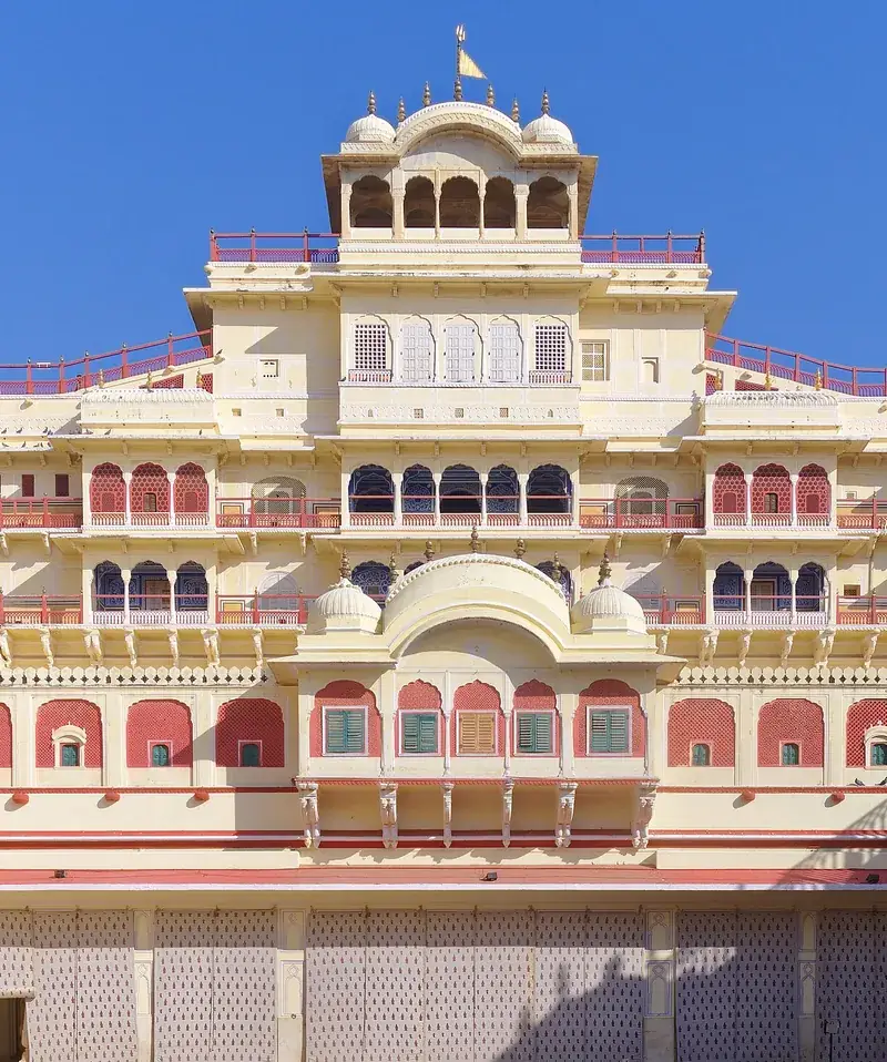 The cream and pink tiers of the Chandra Mahal at the City Palace, Jaipur, against a clear blue sky