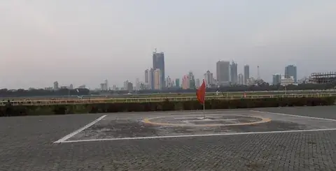 Mahalaxmi Racecourse, Mumbai, at dusk, with the track rail and the city skyline beyond