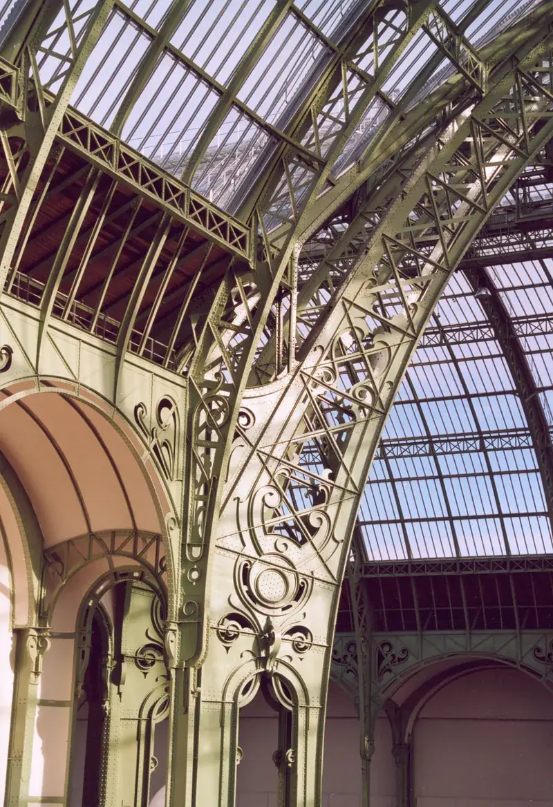 Green Art Nouveau ironwork arches and the glass roof inside the nave of the Grand Palais, Paris