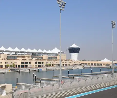 The white-canopied pit building and the race-control tower at Yas Marina Circuit, Abu Dhabi, beside the track