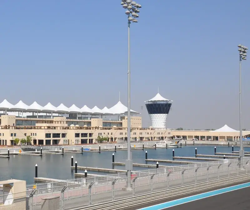 The white-canopied pit building and the race-control tower at Yas Marina Circuit, Abu Dhabi, beside the track